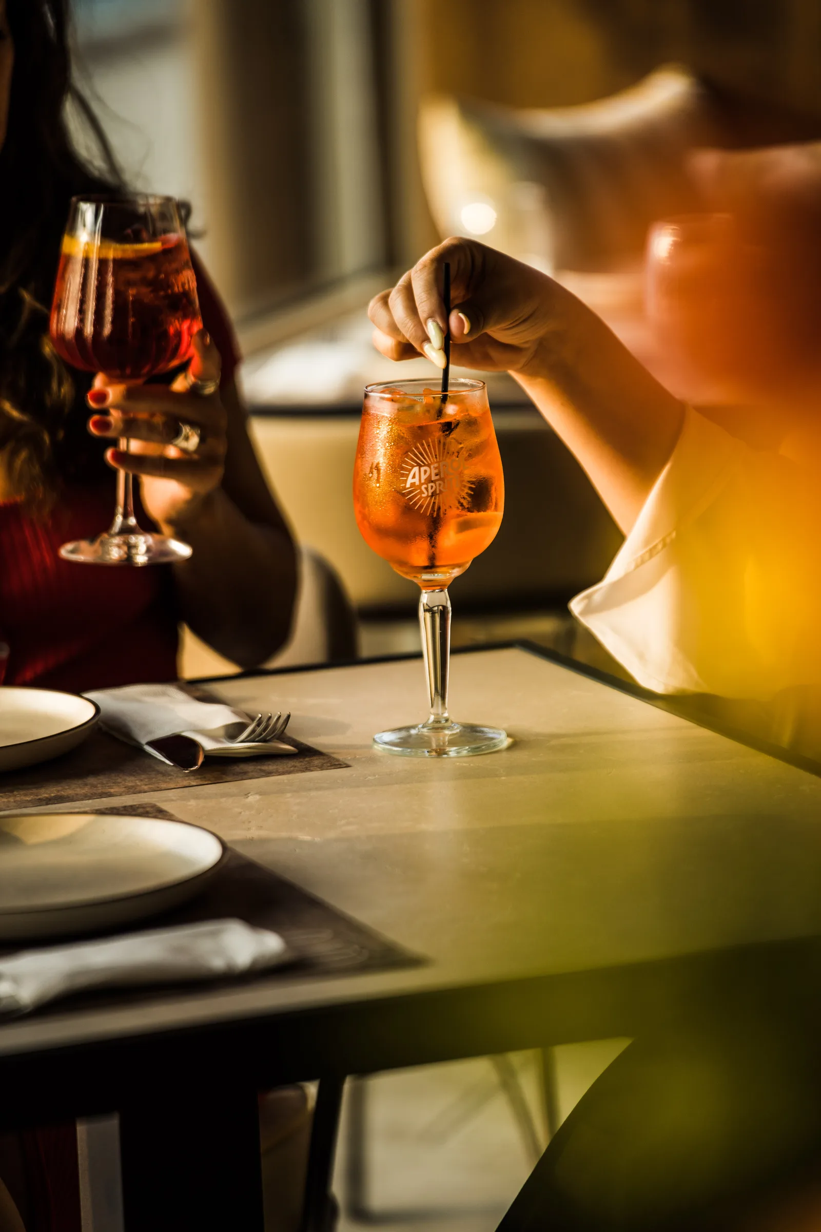 Two spritz cocktails on a restaurant table